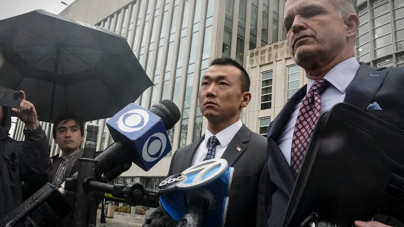 NYPD officer Baimadajie Angwang, center, a naturalized U.S. citizen born in Tibet, and his...